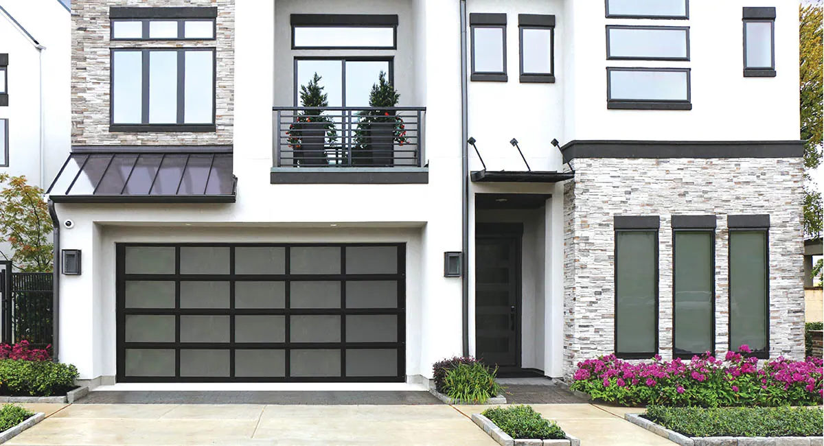 modern house with aluminum black garage door and flowers