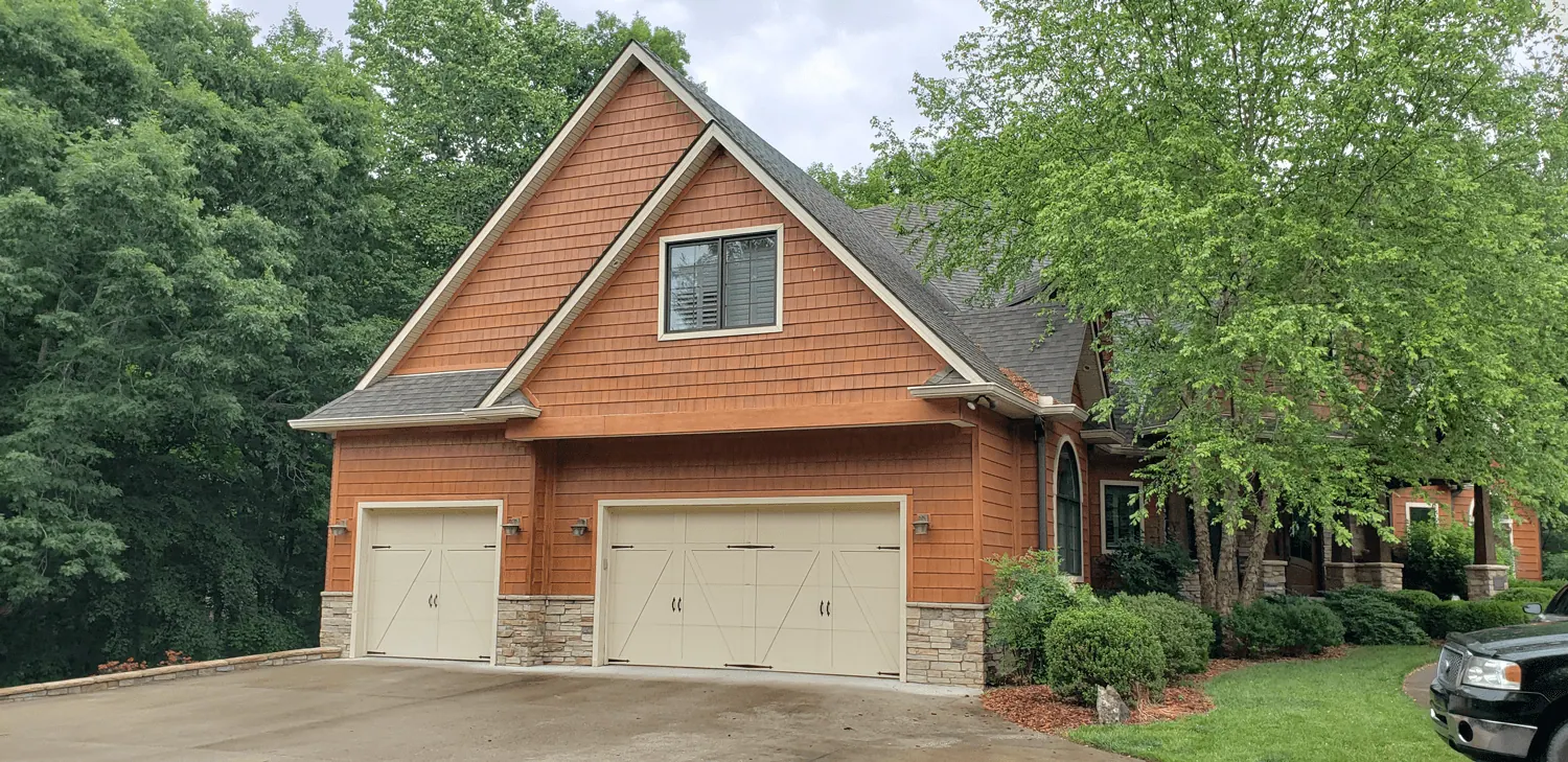 Aristocrat Monarch Series doors on a cedar-shake garage